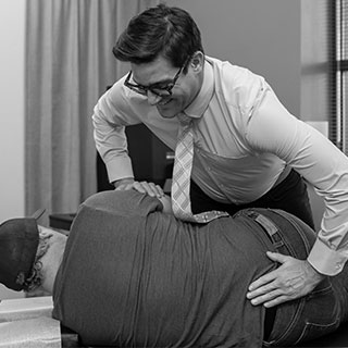 Dr. Bomberg adjusting a women's lower back.