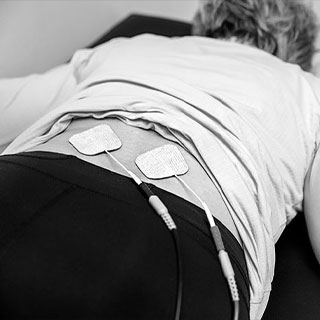 Close up shot of a womens lower back with electrical nerve stimulation patches